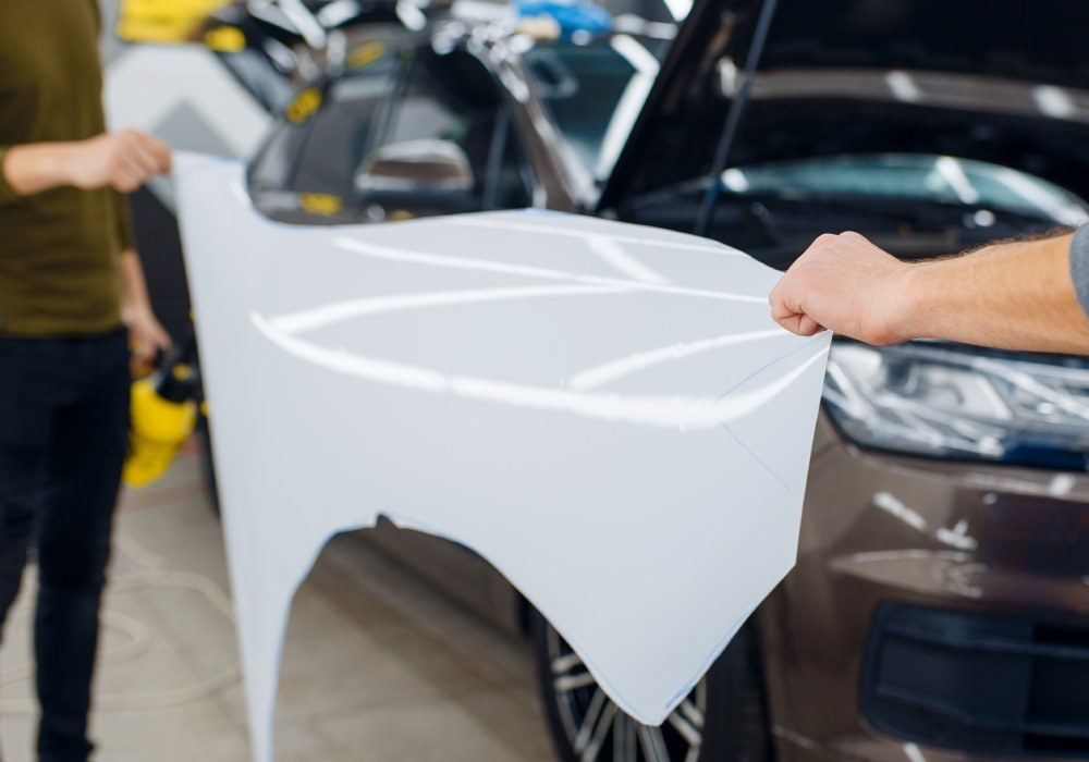 male-workers-holds-template-of-car-protection-film-2023-11-27-05-28-20-utc (1)